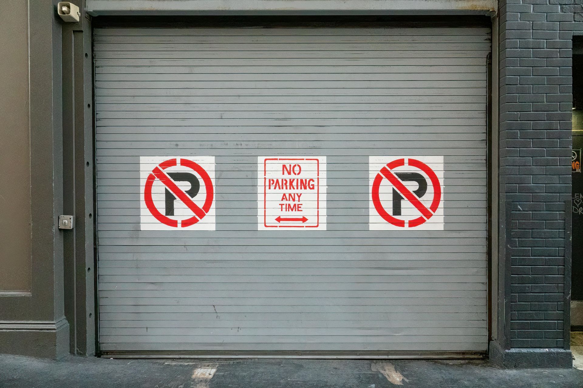Metal garage door with three signs: two 