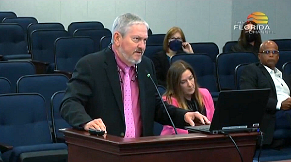 Jim DeBeaugrine, at a lectern, gives a presentation to a Legislative committee.