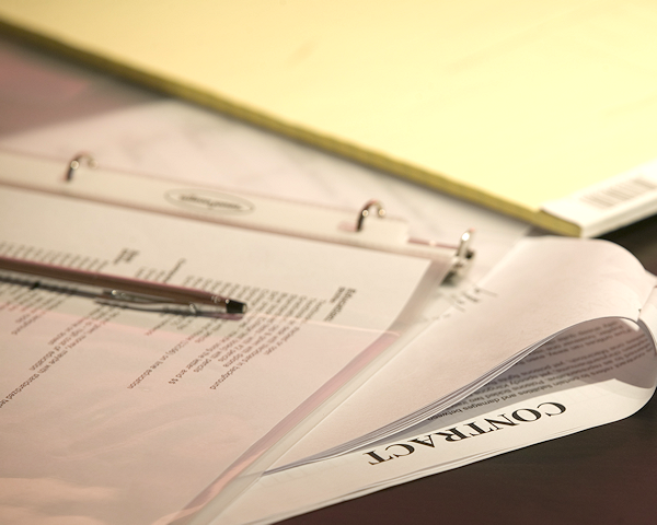 Photo of contract, papers, and a pen.