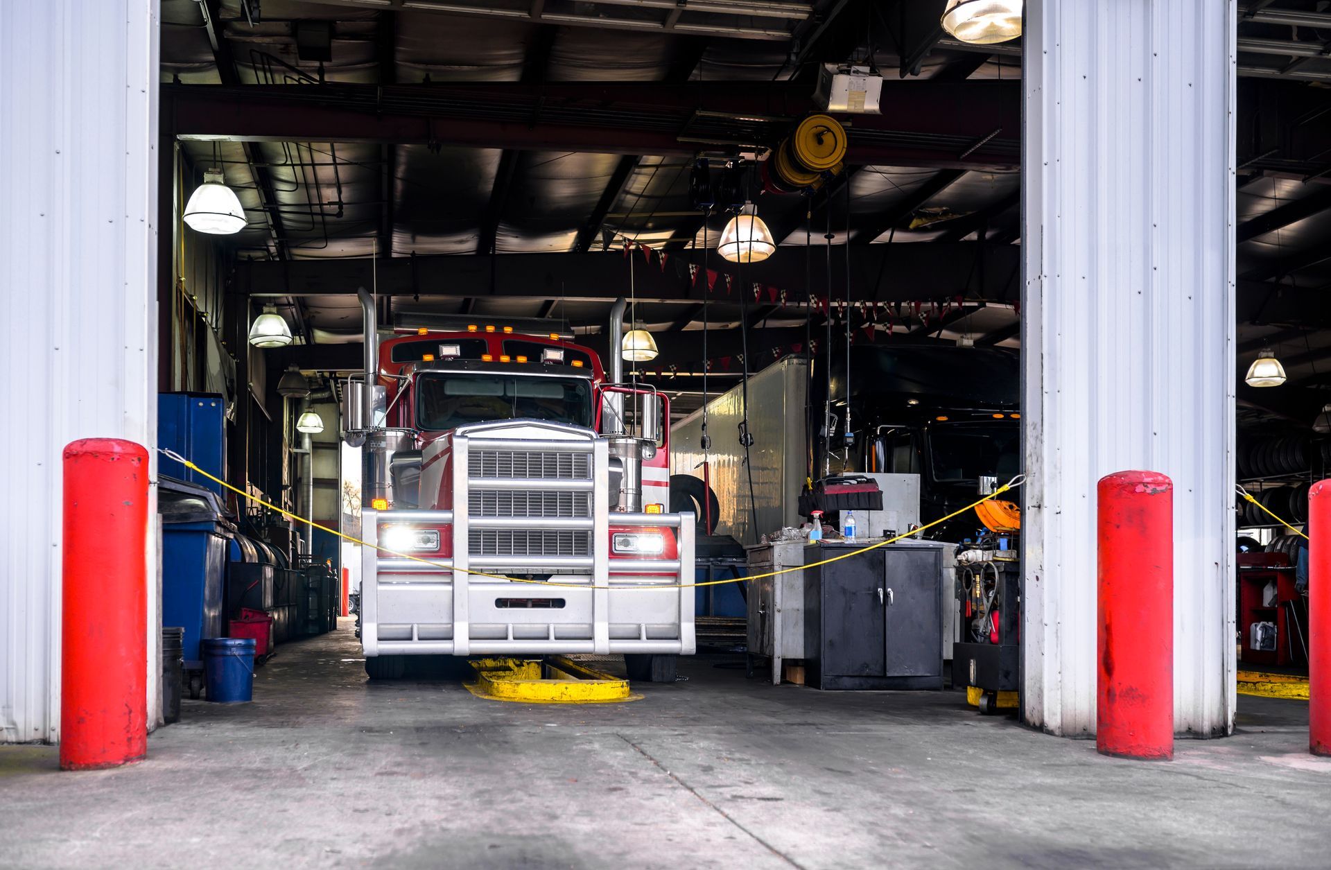 Semi-truck inside a commercial vehicle repair and maintenance service garage Semi-truck inside a commercial vehicle repair and maintenance service garage