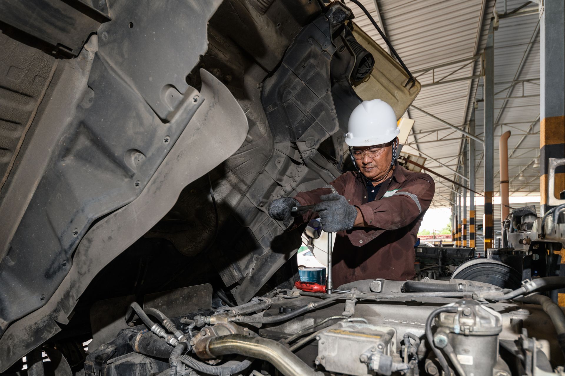 Mechanic working on a truck in a truck repair shop.