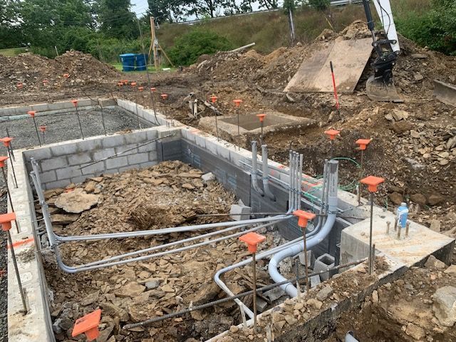 A construction site with a lot of pipes in the dirt.