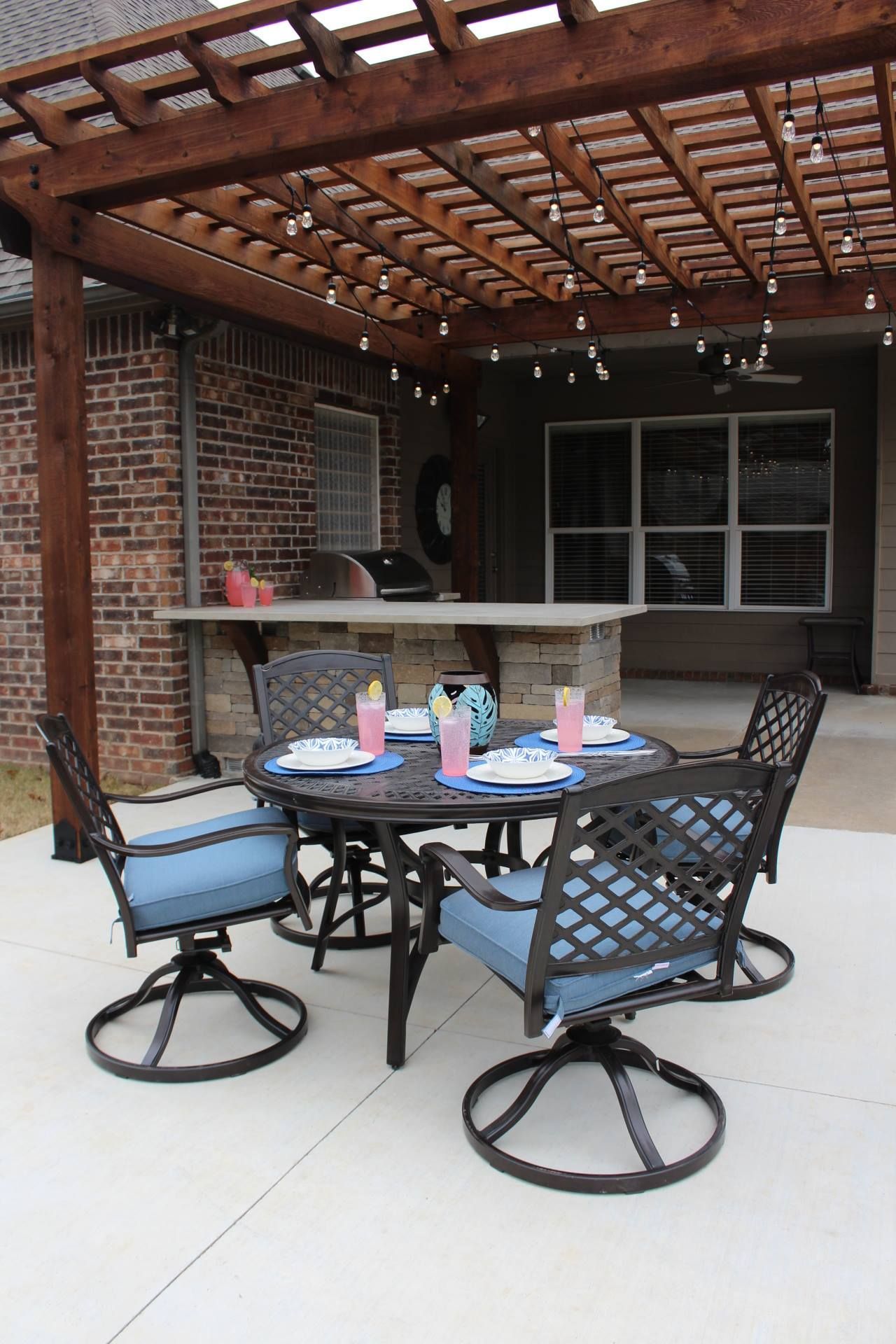 A patio with a table and chairs under a pergola.