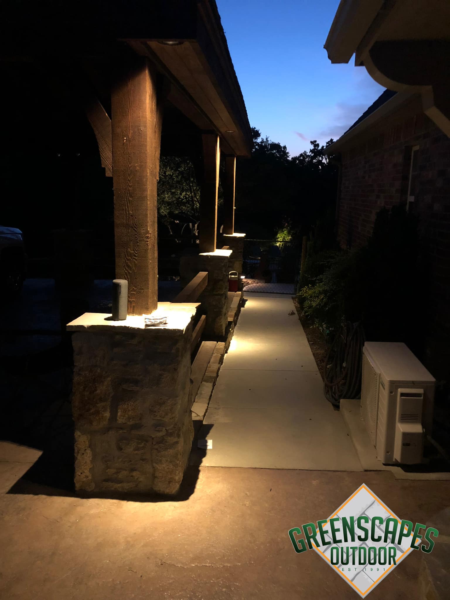 A greenscapes outdoor logo is on the side of a building