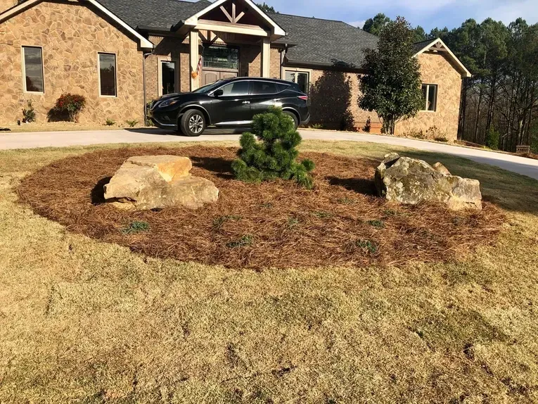 A car is parked in front of a large brick house.