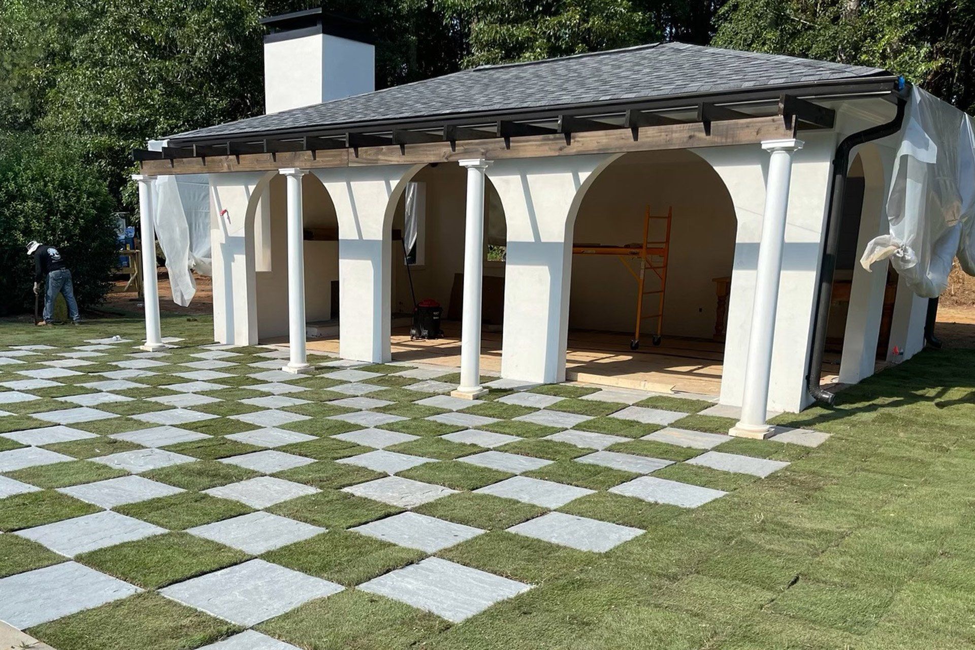 A white house with a checkered floor in front of it.