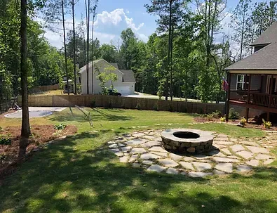 There is a fire pit in the middle of the backyard.