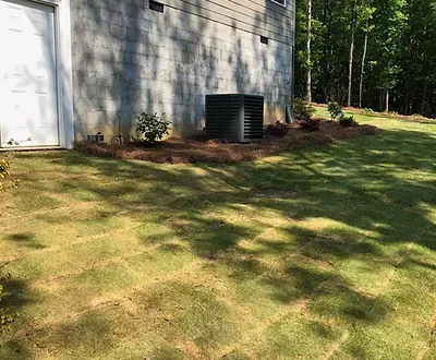 A house with a garage and a lawn in front of it.