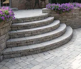 A set of stairs leading up to a patio with purple flowers.