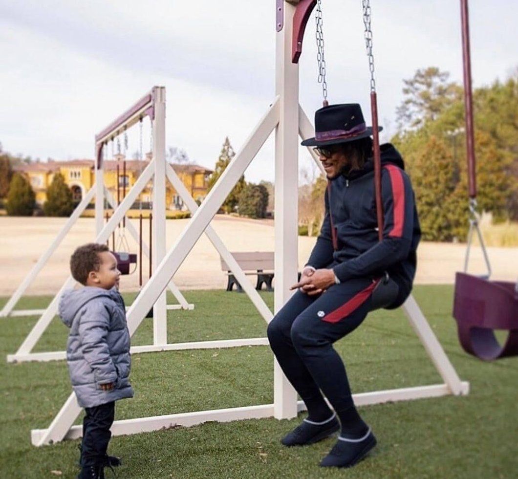 A man sitting on a swing talking to a child.