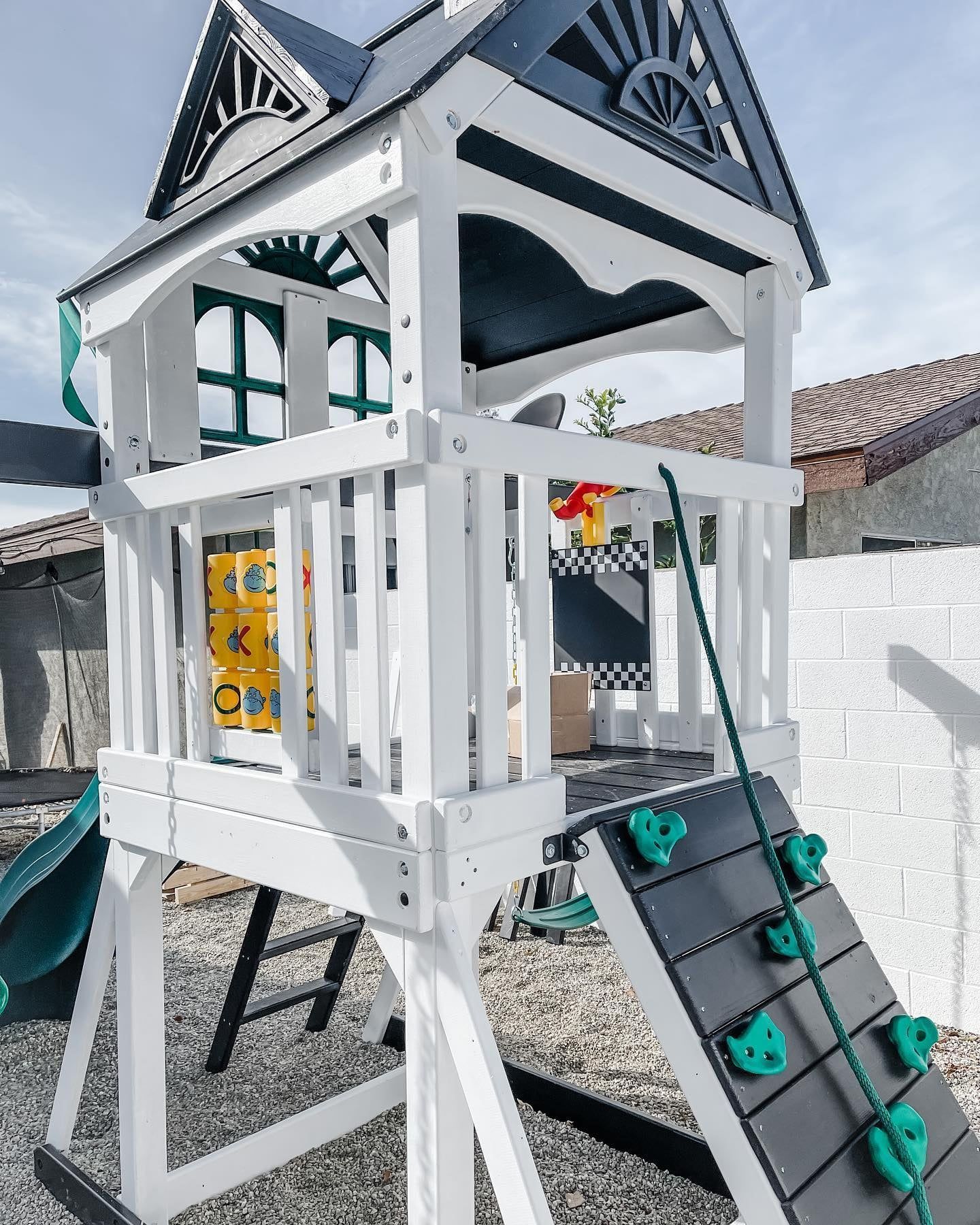 A white and black playground with a slide and stairs.
