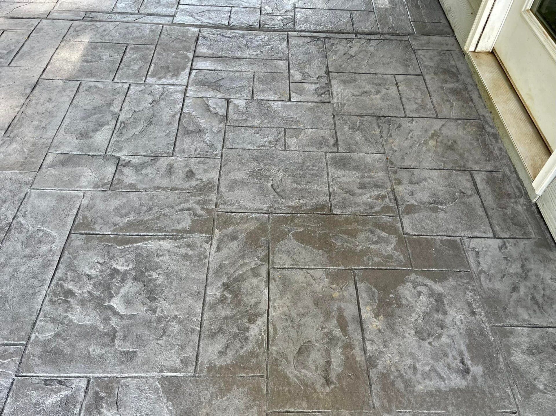 A close up of a concrete floor with a door in the background.