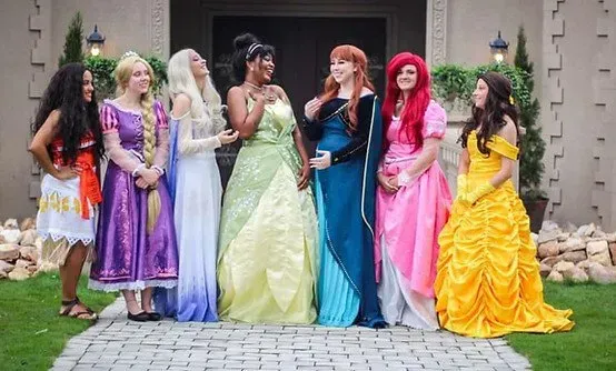 A group of women dressed as princesses are standing next to each other.