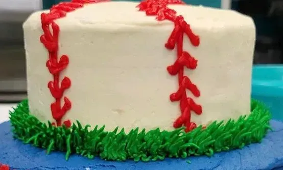 A cake decorated to look like a baseball is sitting on a table.