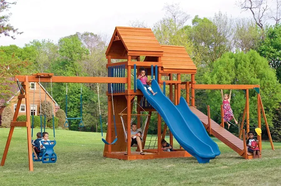 A group of children are playing on a wooden playground set.