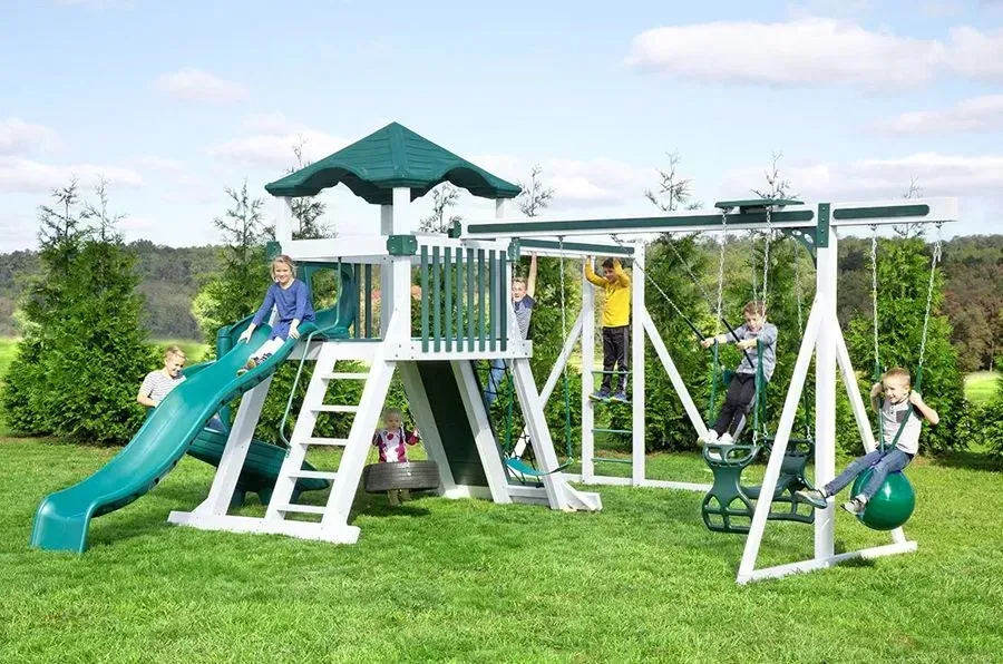 A group of children are playing on a playground with a slide and swings.