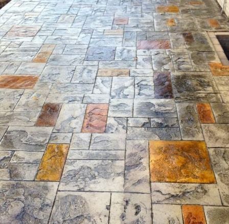 Stamped concrete patio with gray blocks and colorful rectangular accents.