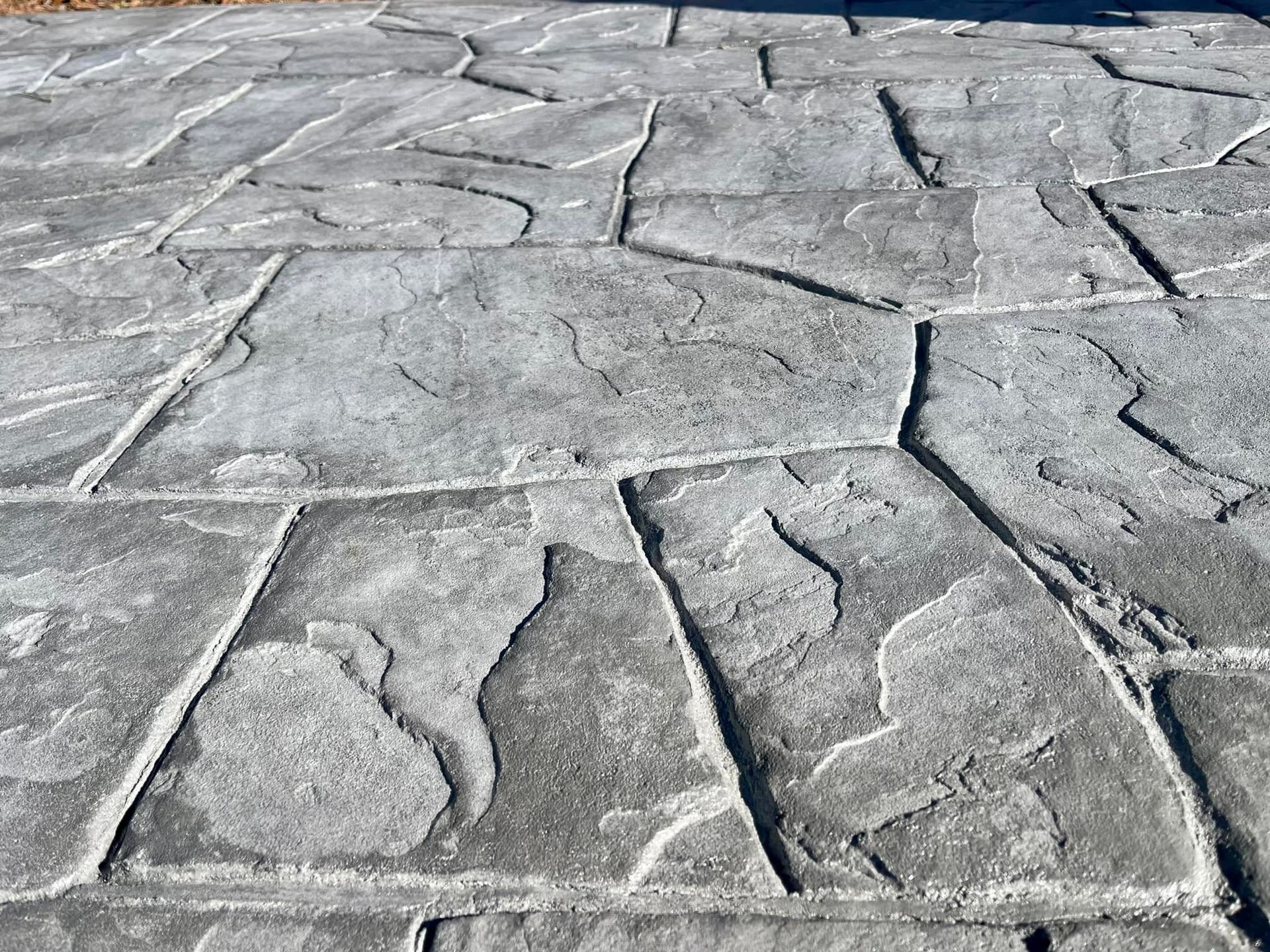 Gray concrete stamped with flagstone pattern.