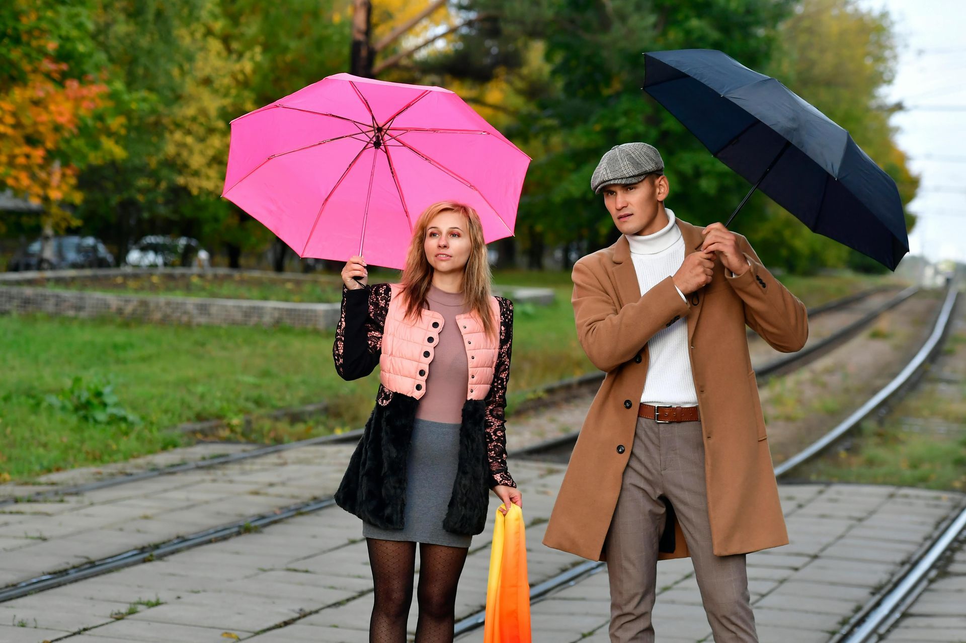 Couple reviewing a document with a person, indoors. They smile, looking at the person who is holding the document.