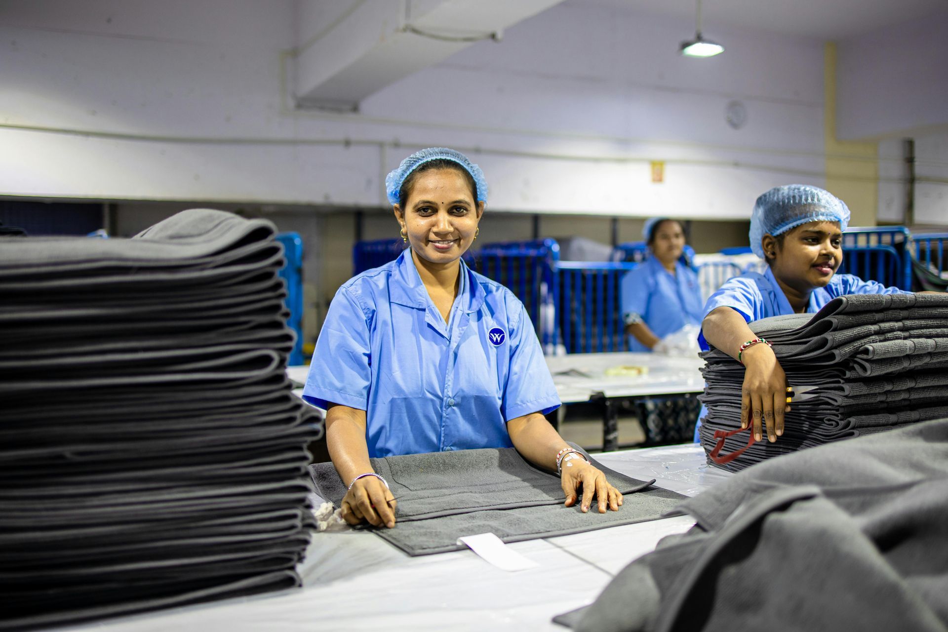 Two people sitting together on a tiled floor by an open door, looking out at a body of water and a wooden deck.