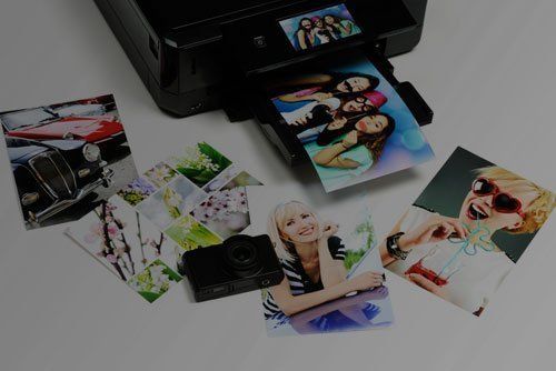 a printer is printing a bunch of pictures on a table .