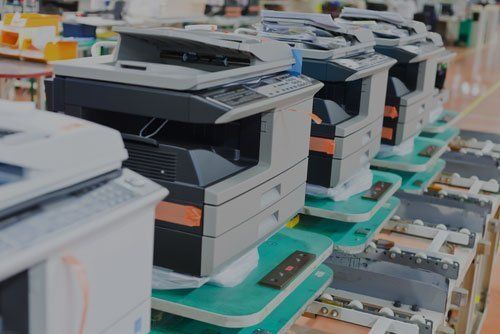 a row of printers are sitting on a conveyor belt in a factory .