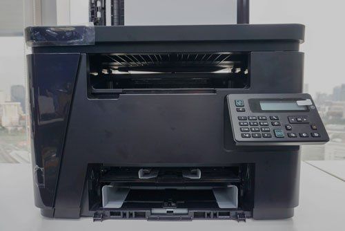 a black printer is sitting on top of a white table .