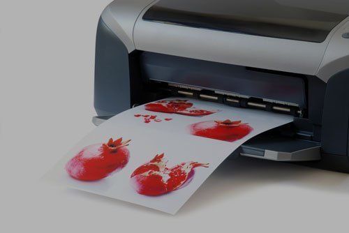 a printer is printing a picture of pomegranates on a piece of paper .