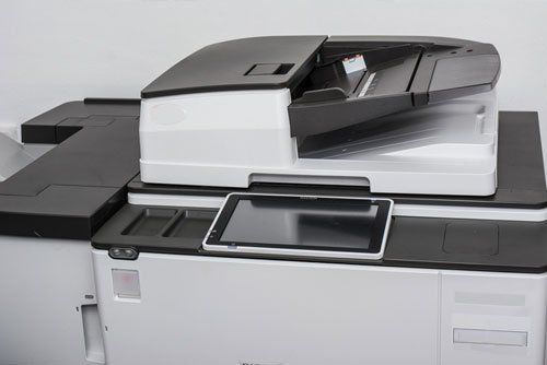 a black and white printer with a tablet on top of it .