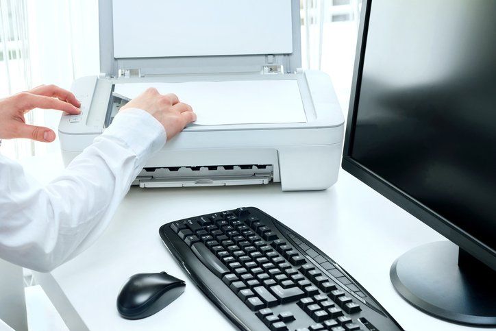 a person is using a printer next to a keyboard and mouse