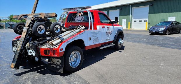 A red and white tow truck is parked in front of a building.