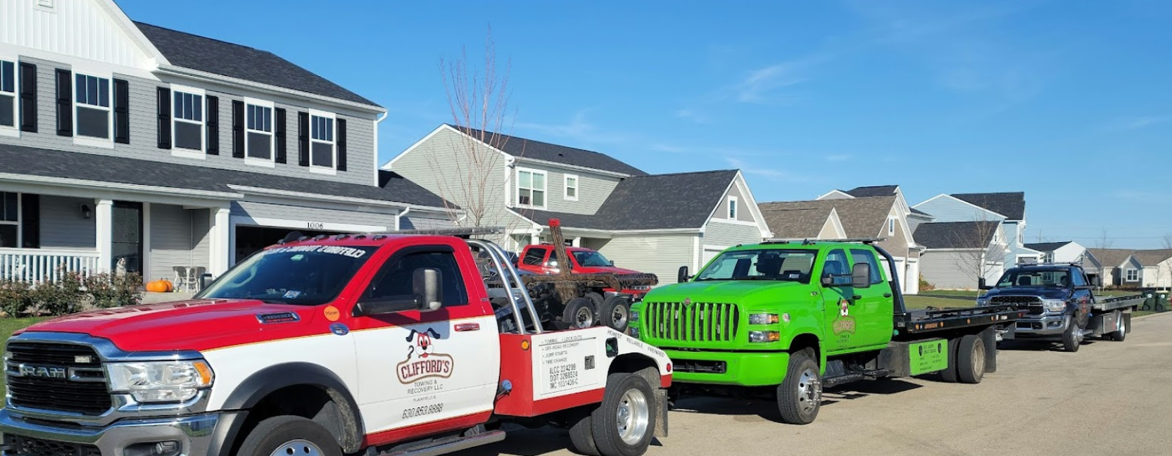 A row of tow trucks are parked in front of a house.
