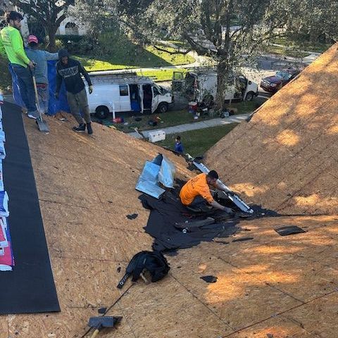 a group of people are working on a roof .