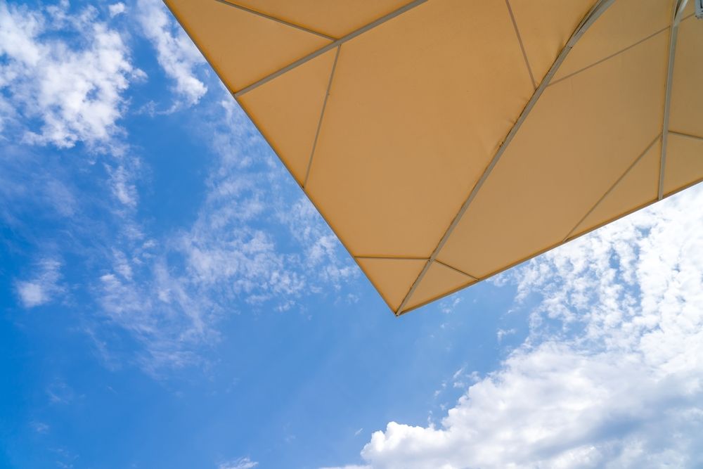 Exterior brick building with three windows, each covered by dark gray rolling shutters.