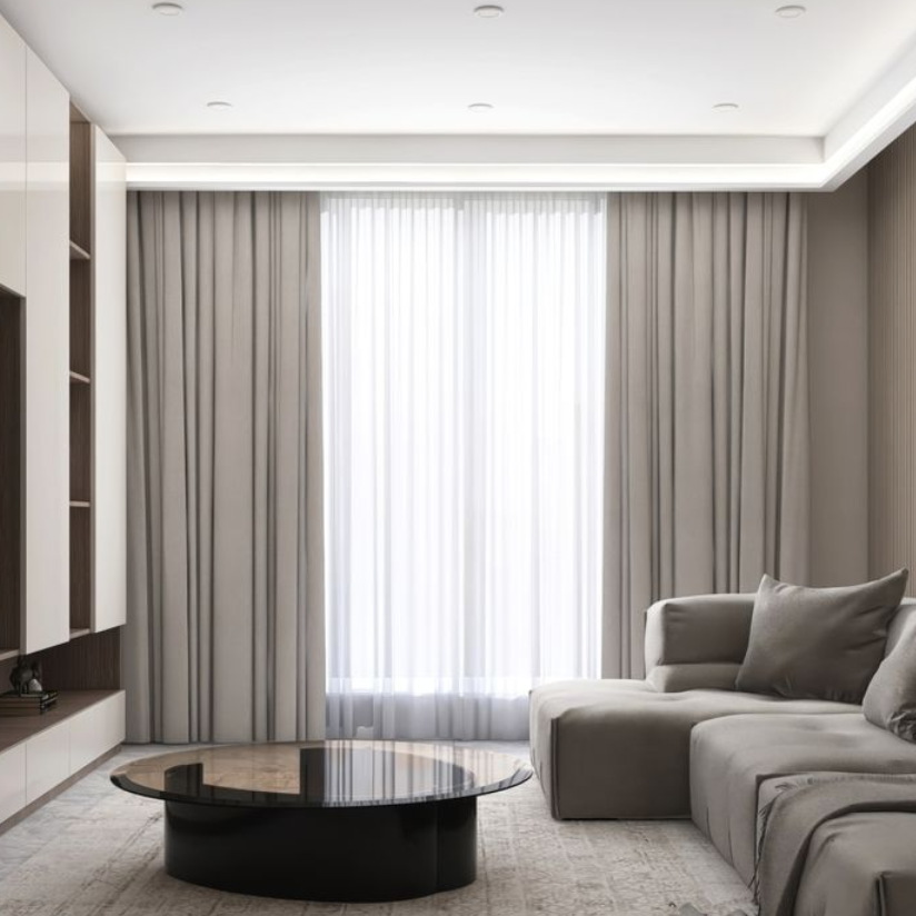 Living room with gray sofa, coffee table, window with sheer curtains, and built-in shelving.