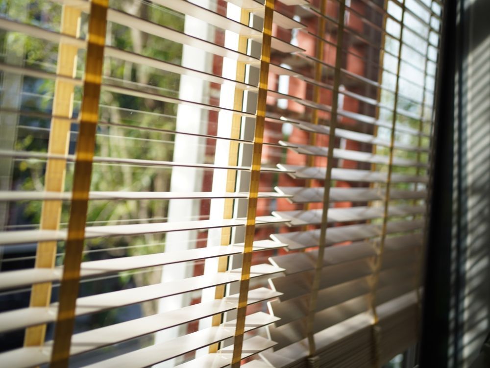 Open-concept kitchen and dining area with hardwood floors, black cabinets, and a long wooden table.