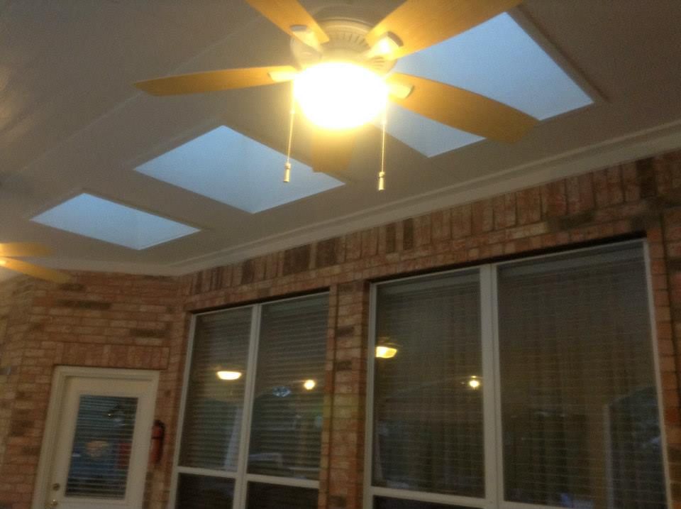 Room with brick walls, ceiling fan, skylights, and windows with blinds.