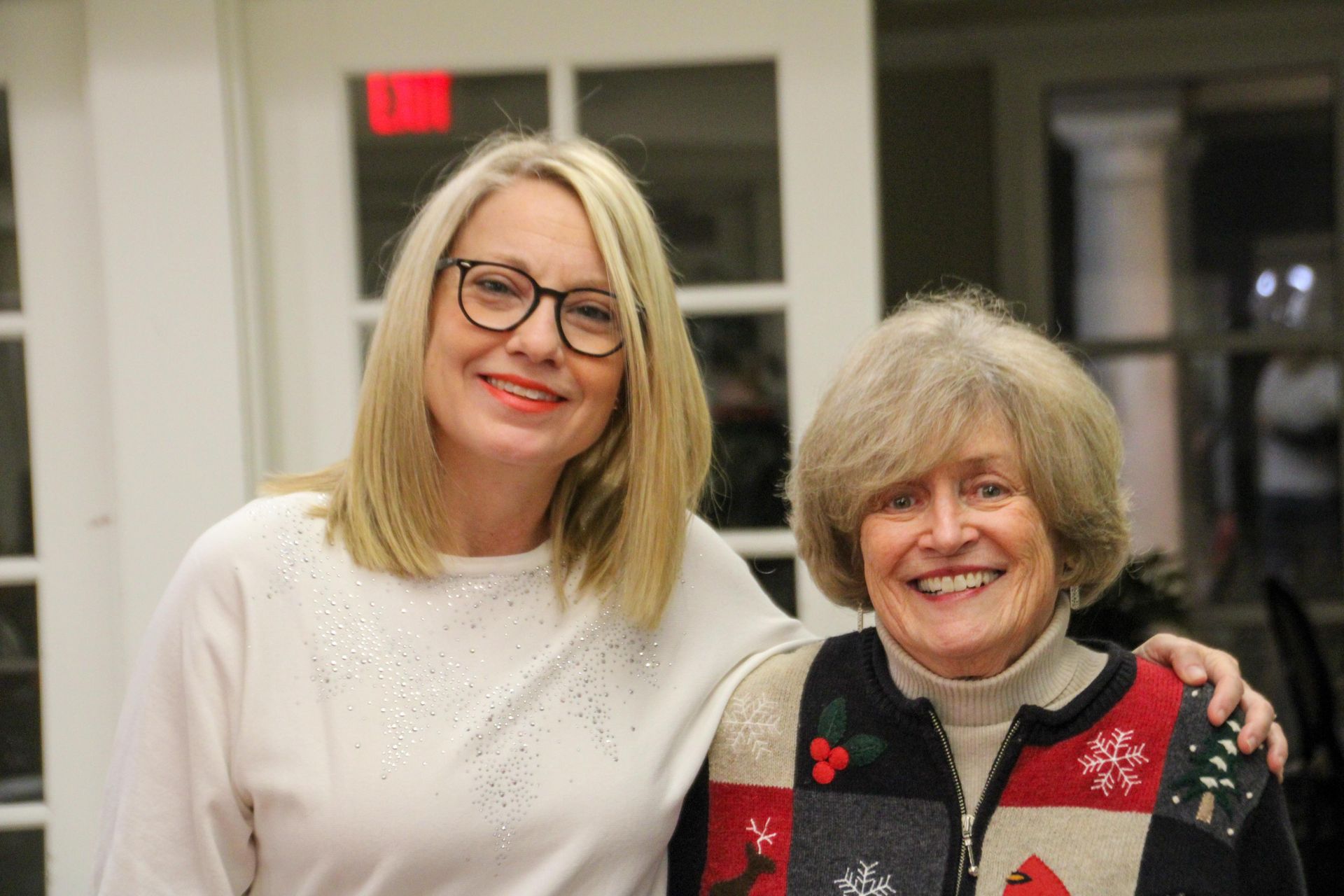 Two women are posing for a picture together and smiling for the camera.