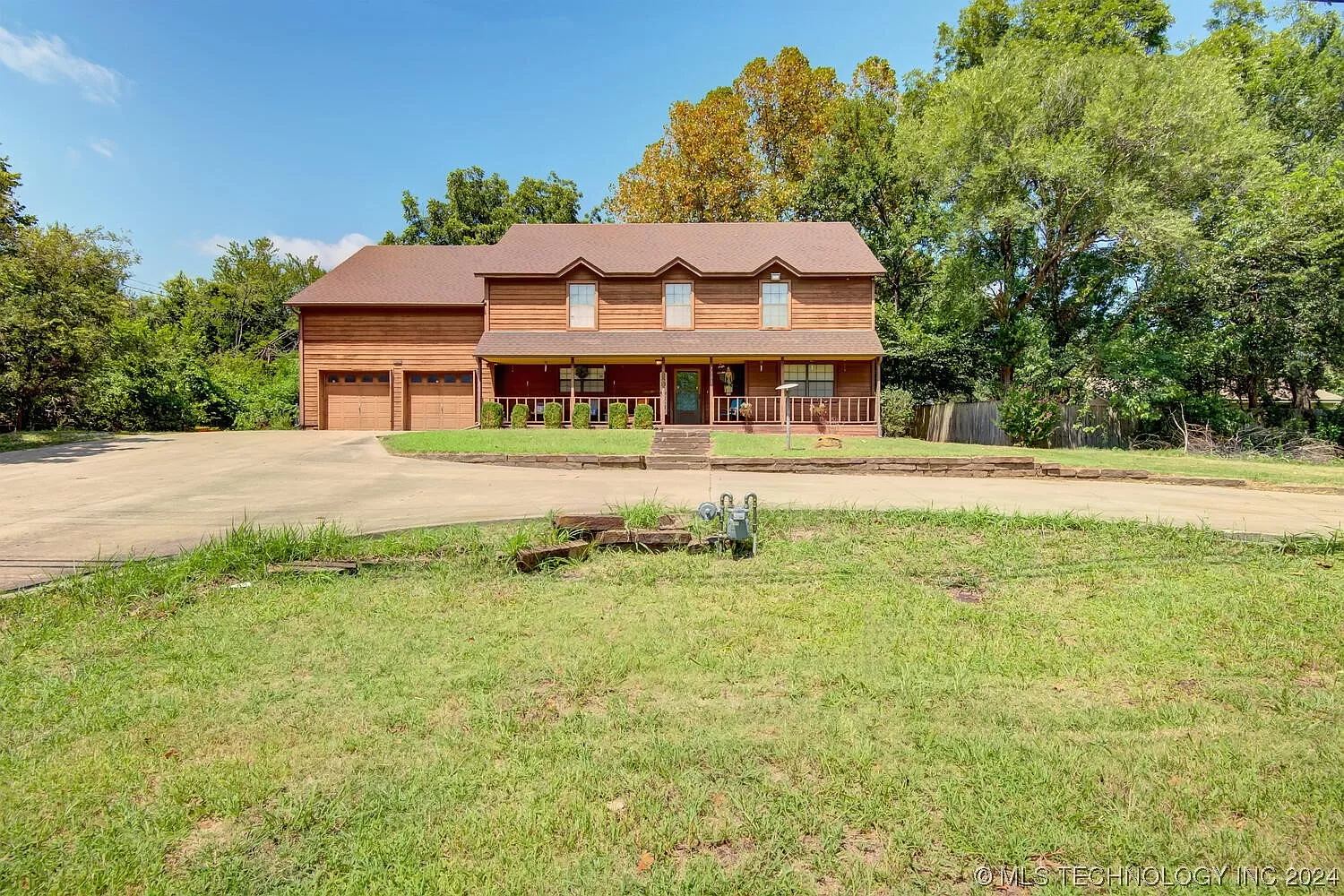 A large log cabin sitting on top of a lush green field.