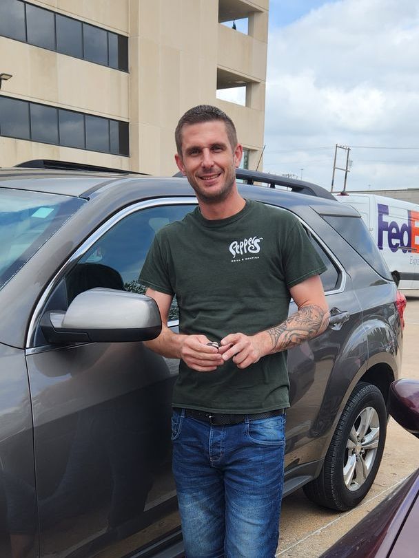 A man is standing in front of an SUV.