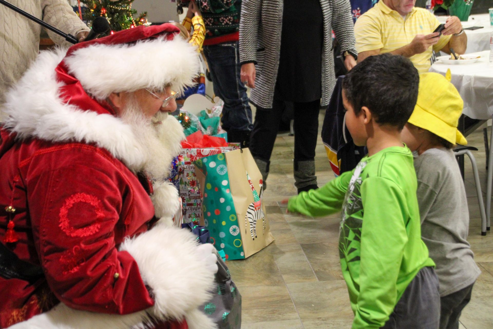 A man dressed as santa claus is talking to two children