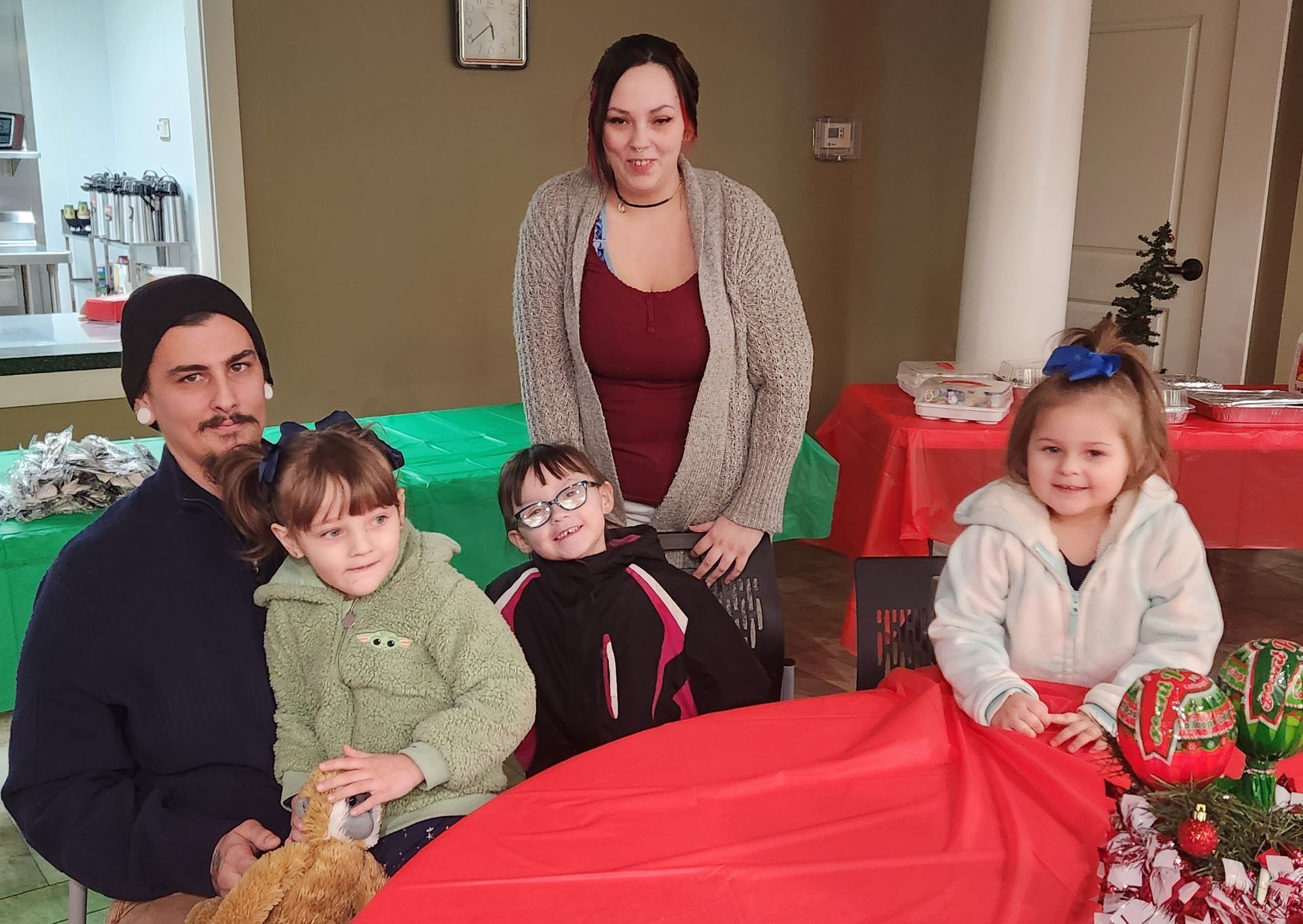 A family is posing for a picture while sitting at a table.
