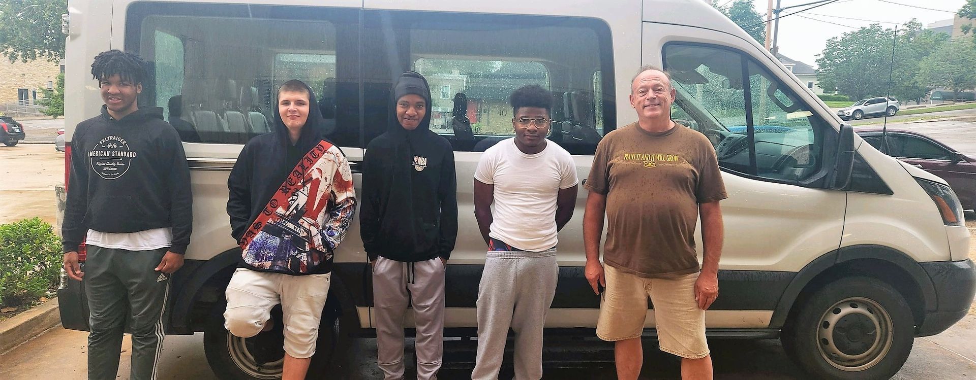 A group of people are standing in front of a van.