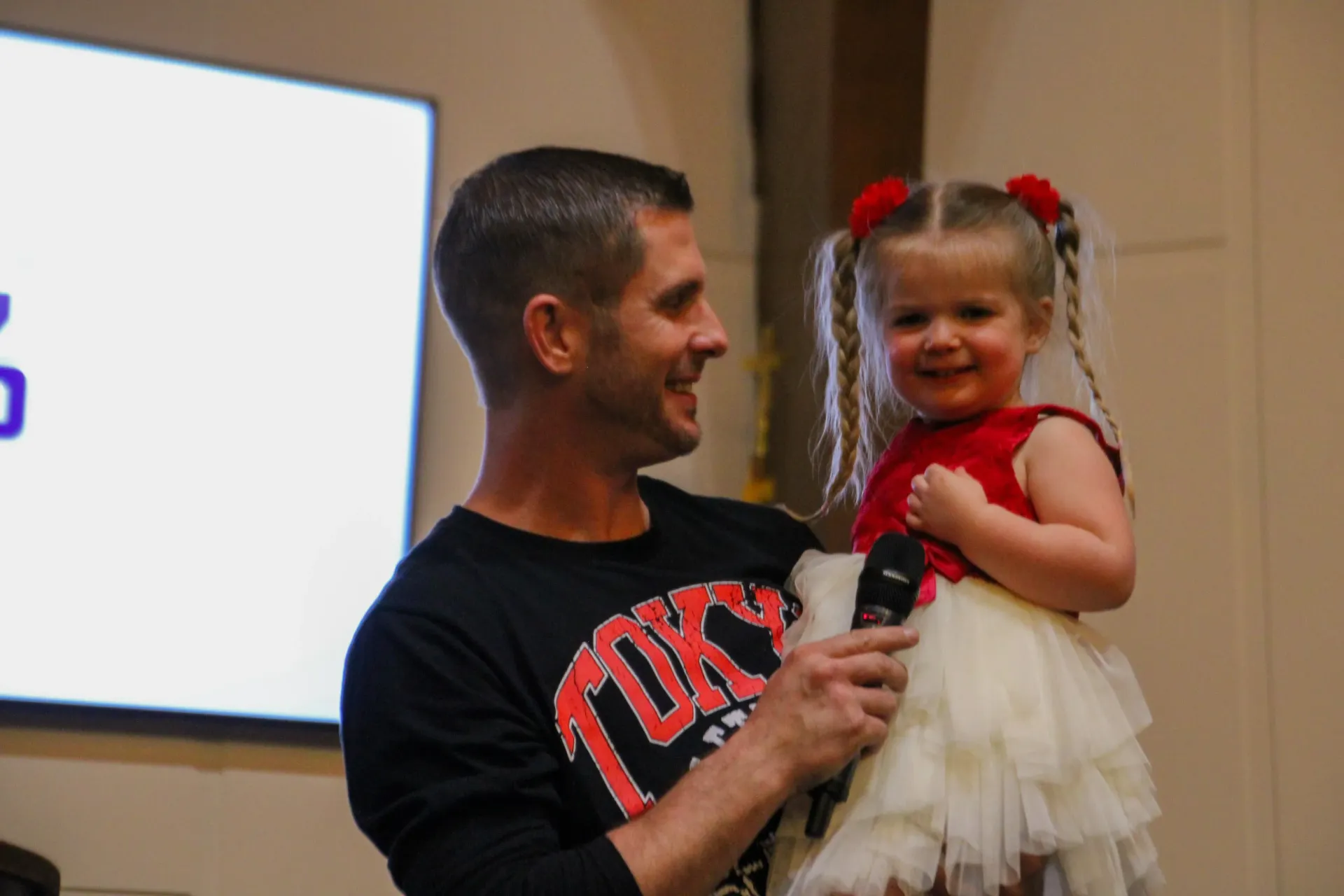 A man is holding a little girl in his arms.