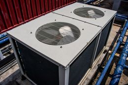A large air conditioner is sitting on the roof of a building.