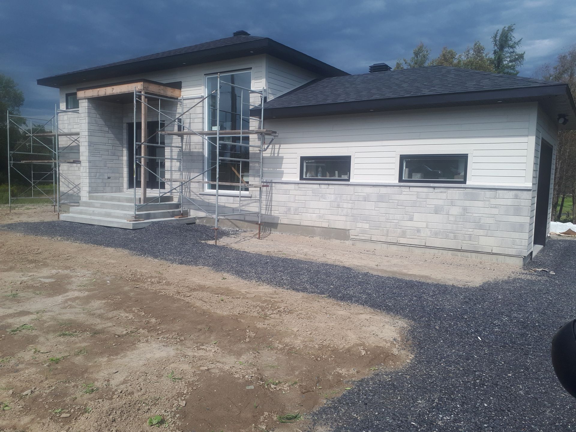 Une maison est en construction au milieu d'un champ de terre.