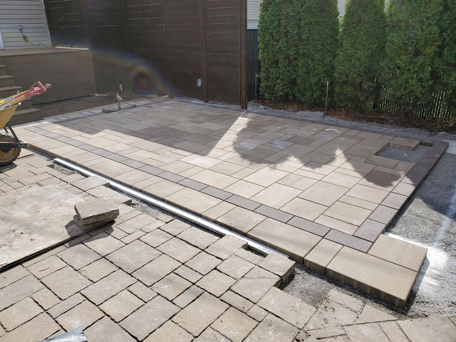 Une passerelle en brique est en cours de construction dans une cour.