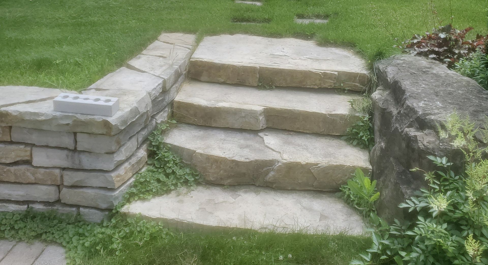 Un ensemble de marches en pierre menant à un mur de pierre dans une cour.