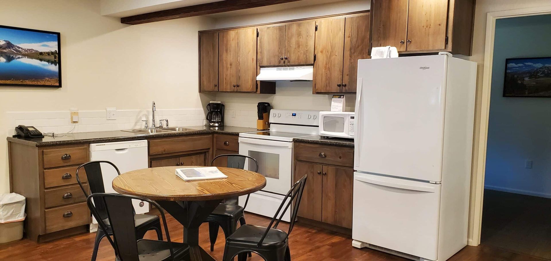 A kitchen with a table and chairs and a refrigerator.