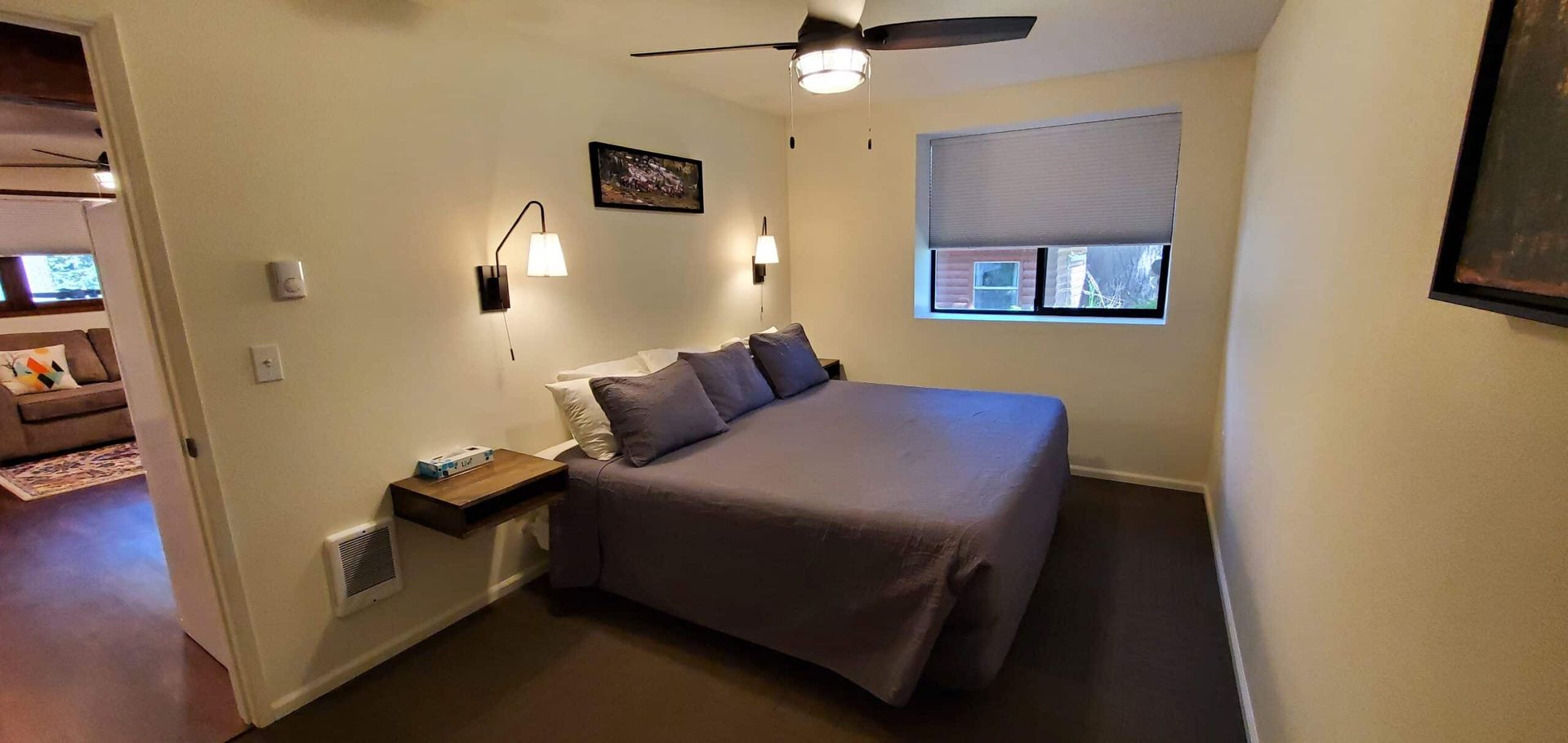A bedroom with a king size bed and a ceiling fan.